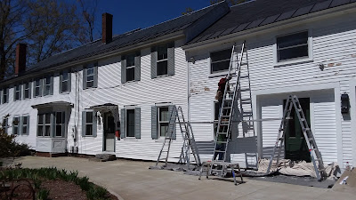 Large white house being painted